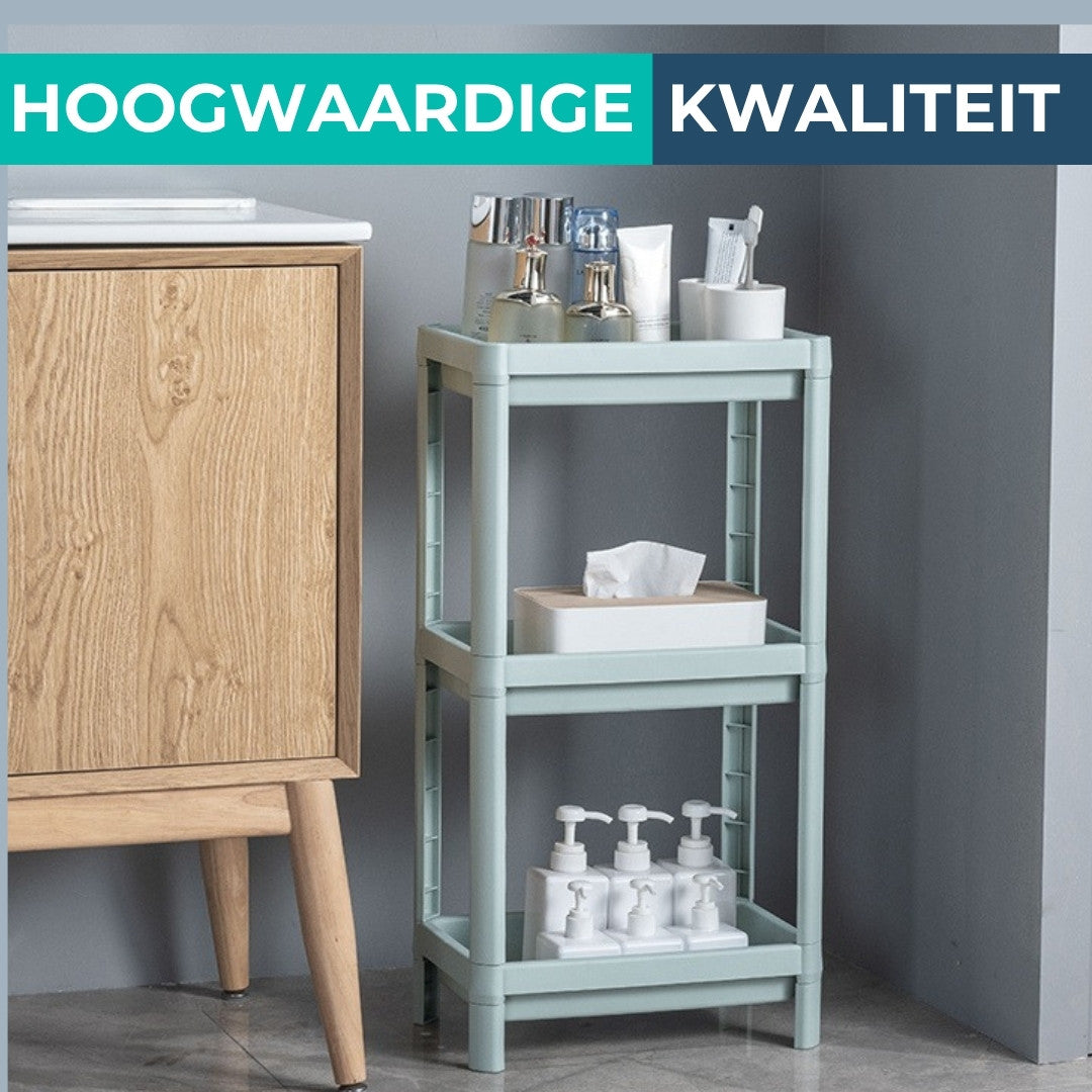 Smal pastelgroen badkamerrek met 3 etages in de badkamer naast een houten kastje, gevuld met toiletartikelen.
